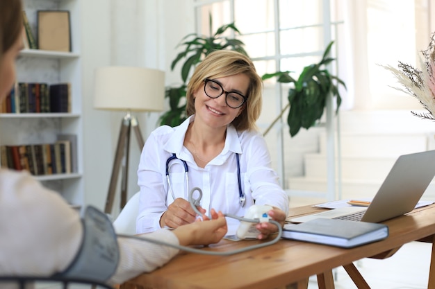 Terapeuta médico de mediana edad en consulta con el paciente en la oficina.