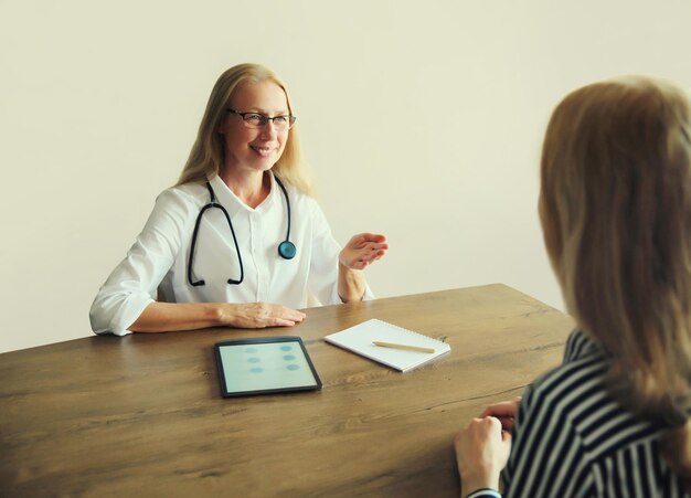 Una terapeuta mujer hablando con una paciente prescribe medicamentos en la oficina de la clínica