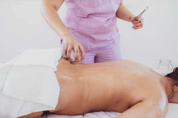 Terapia de hijama com copos de vácuo aquecidos na pele do paciente para curar problemas de dor