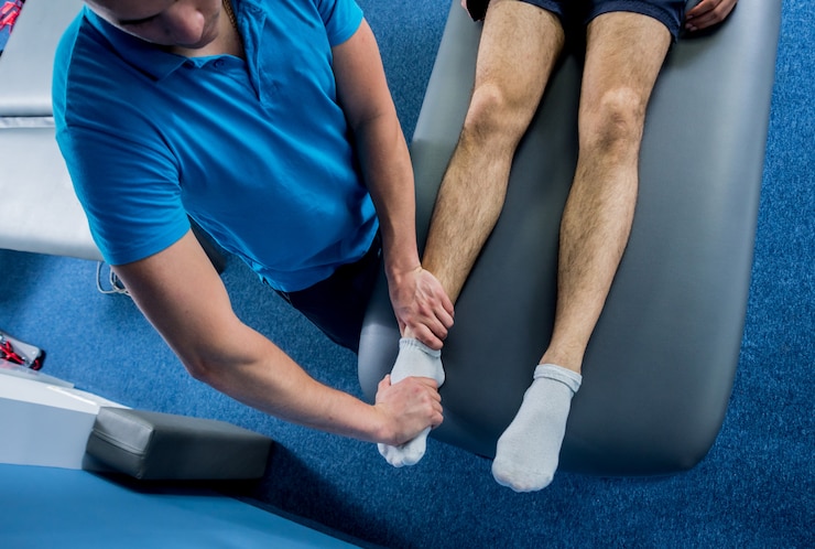 Foto terapia de reabilitação. fisioterapeuta trabalhando com jovem paciente do sexo masculino