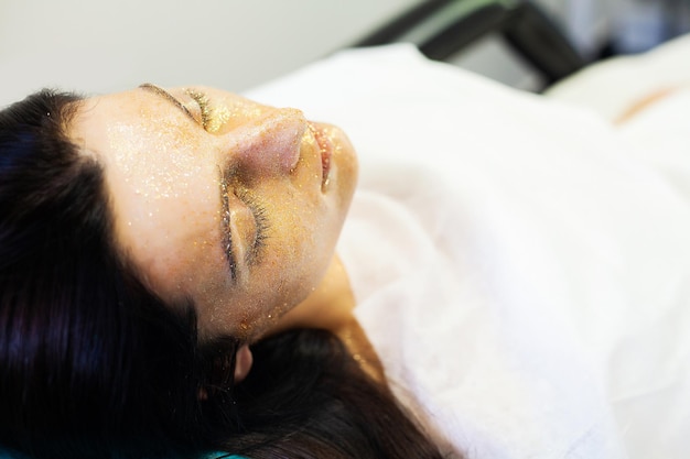 Terapia de spa para jovem com máscara facial no salão de beleza