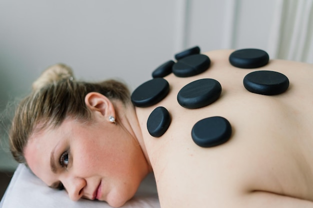 Terapia de masaje con piedras calientes para mujer gorda, maestro masculino