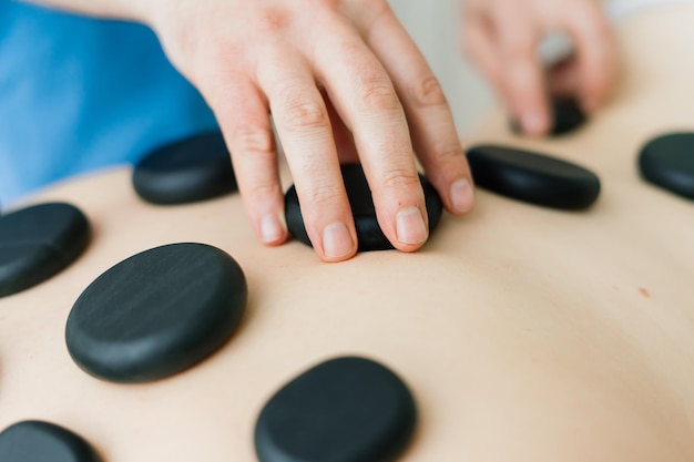 Terapia de masaje con piedras calientes para mujer gorda, maestro masculino