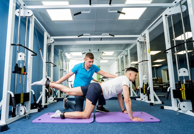 Terapia de rehabilitación. Joven haciendo ejercicios en estera