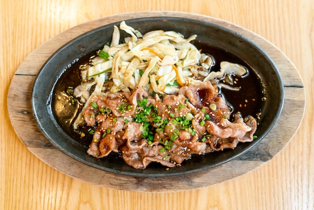 Teriyaki-Schweinefleisch in heißer Pfanne mit Kohl - japanischer Essensstil