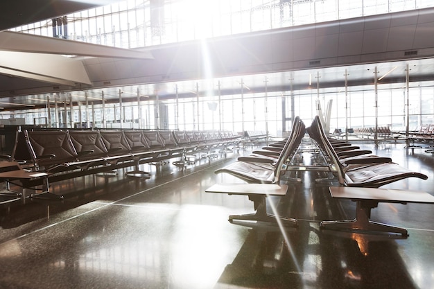 Terminal de aeroporto moderno com assentos de couro preto ao pôr do sol.