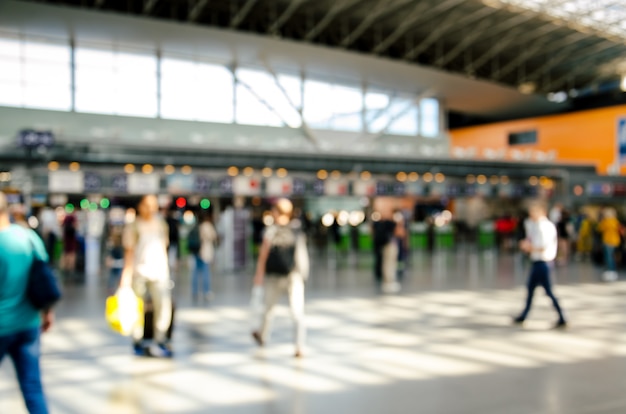 Terminal do aeroporto internacional com pessoas borradas