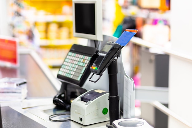 Foto terminal de liquidación bancaria en el primer plano de la caja en un fondo borroso de la tienda