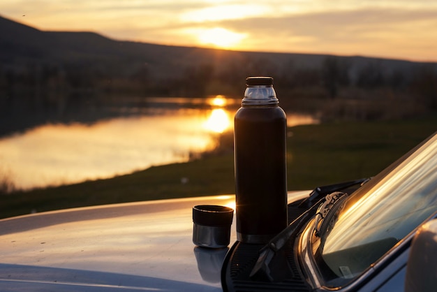 Termo en el capó del coche; Descansa y relajate; Paisaje de otoño