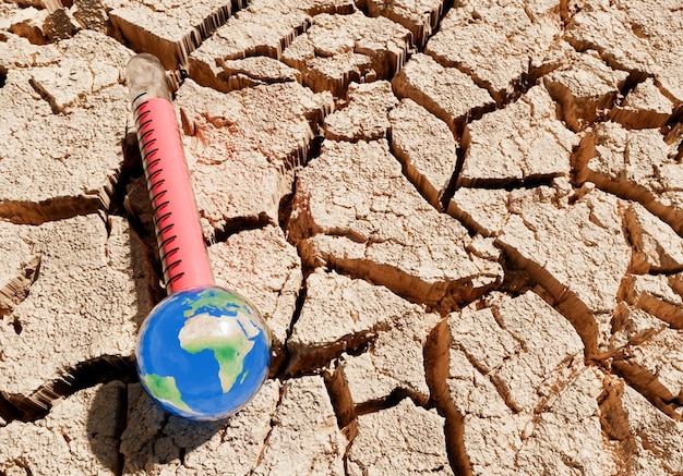 Foto termômetro de terra em solo seco e rachado