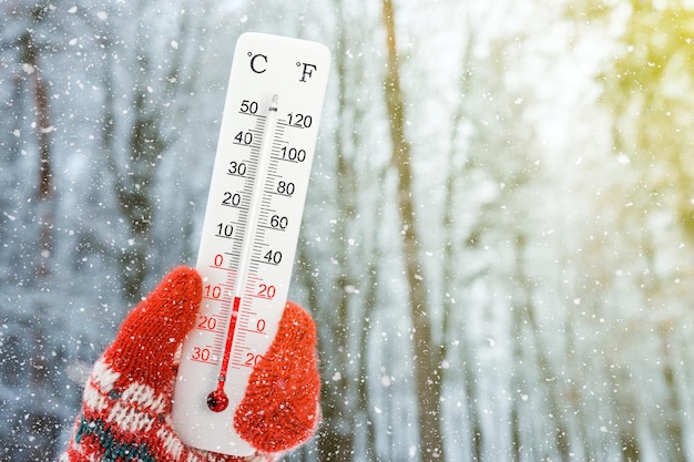 Termómetro de escala blanca celsius y fahrenheit en la mano Temperatura ambiente menos 8 grados centígrados