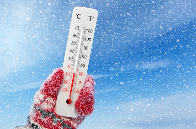 Foto el termómetro de escala celsius y fahrenheit en la mano muestra la temperatura menos 5 grados celsius