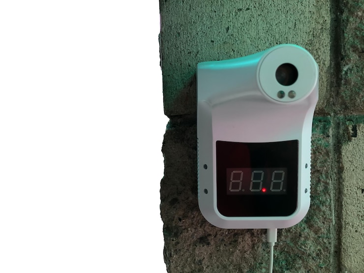 Foto termómetro infrarrojo en la pared con espacio de copia