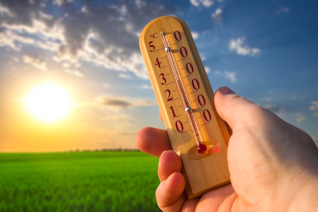 Termómetro para medir la temperatura en la naturaleza contra el fondo del cielo en el clima caluroso del verano