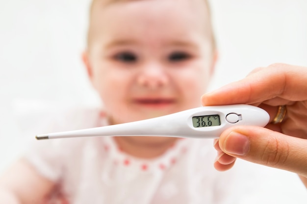 Foto termómetro para medir la temperatura de un niño enfermo.