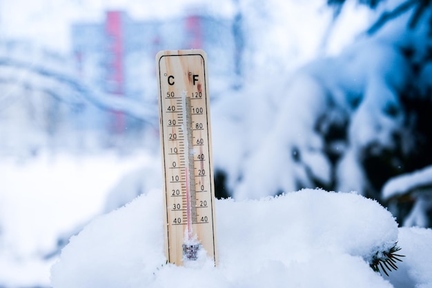 Termômetro na neve com baixas temperaturas em celsius ou fahrenheit no inverno.