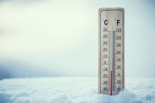 El termómetro en la nieve muestra bajas temperaturas bajo cero. Temperaturas bajas en grados centígrados y fahrenheit. El frío invierno diez bajo cero.