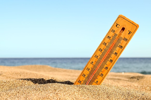 Foto el termómetro en la playa de arena