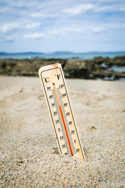 Termómetro en la playa marcando altas temperaturas. Cambio climático. Calentamiento global. Problema ecológico