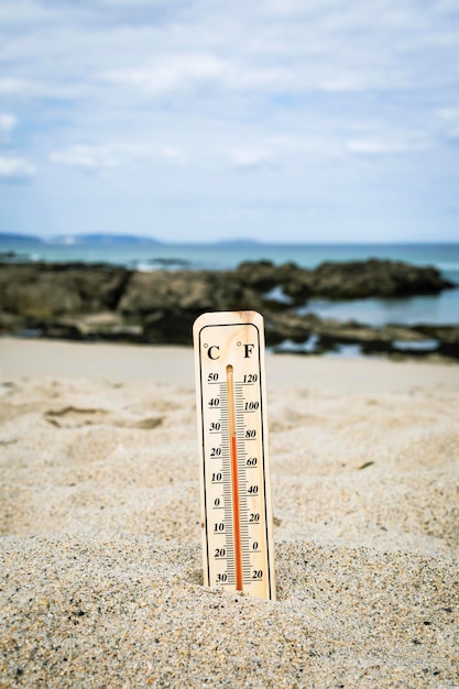 Termómetro en la playa marcando altas temperaturas. Cambio climático. Calentamiento global. Problema ecológico