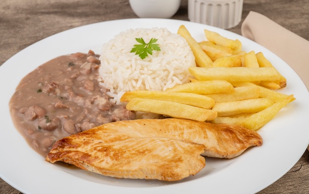 Ternera, arroz, frijoles y patatas fritas. Plato típico brasileño.