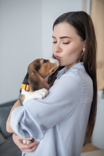 Ternura. A dona do animal segurando seu cachorrinho fofo e parecendo feliz