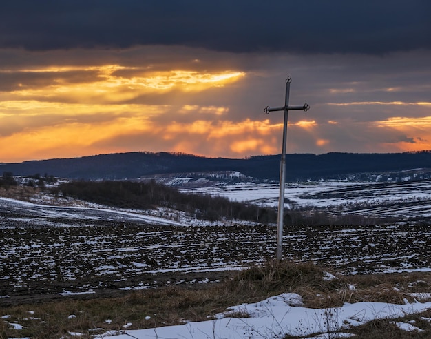 Terra arável de terra preta coberta com a última neve no início da primavera Calmo pôr do sol noturno na zona rural ucraniana de Lviv