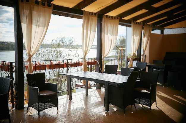 Foto terraço aberto em um café de verão vazio com vista para o rio