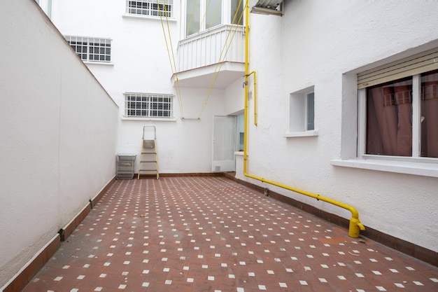 Terraço de piso baixo com piso de barro e paredes pintadas de branco