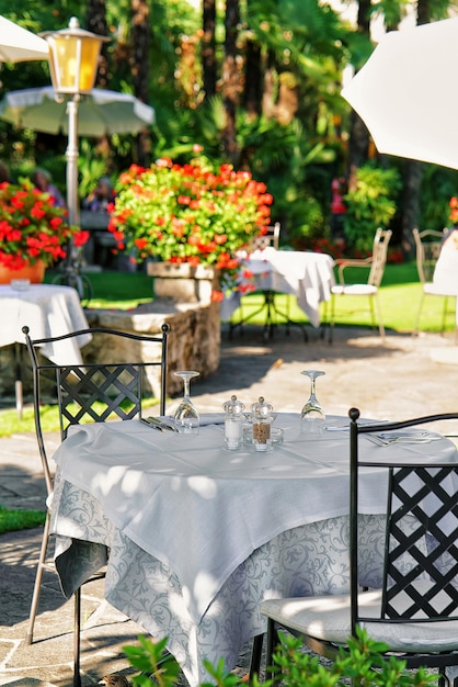 Terraço de restaurante típico com cadeiras e mesas prontas para uma refeição no luxuoso resort em Ascona, no Lago Maggiore, no cantão de Ticino, Suíça.