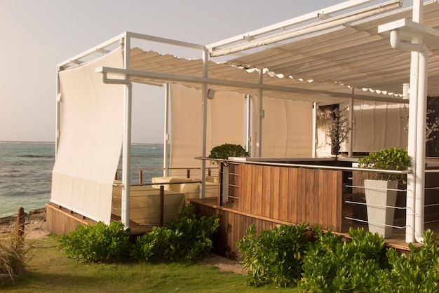 Terraço protegido por véus de tecidos com vista para o mar