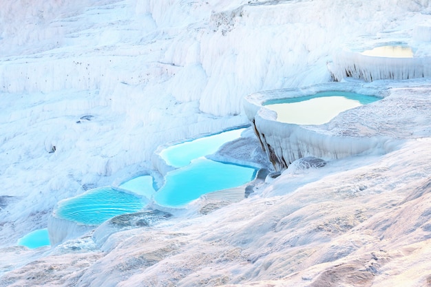 Terraços de travertino naturais de Pamukkale cheios de água azul