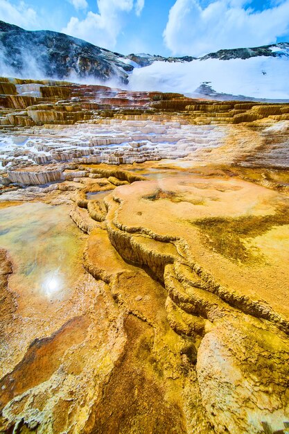 Terraços sem fim nas fontes termais de Yellowstone no inverno com nuvens de vapor de enxofre