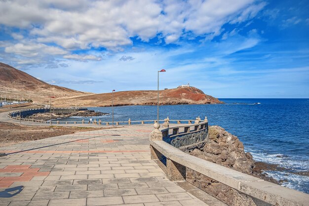 Terraplén de piedra vacío Una vista del océano y un pequeño faro en el muelle de entrada de la isla
