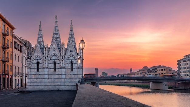 Foto el terraplén del río arno con la antigua iglesia de chiesa di santa maria della spina al atardecer pisa italia