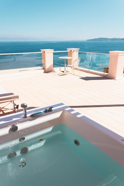 Foto terrasse mit liegestühlen, whirlpool im freien und meerblick, entspannter urlaub in einem mediterranen resort