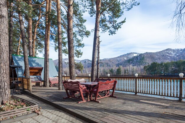 Una terraza abierta de verano con una mesa cerca del río azul que fluye y las altas montañas Un hermoso paisaje de la zona de relajación