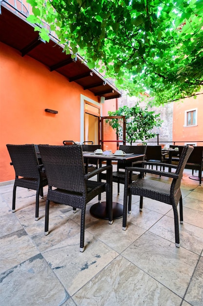 Terraza del interior del restaurante de desayuno del Hotel en el fondo. Habitación blanca de arquitectura vacía. Veranda de Bar con mesas y sillas. Estilo vintage ligero. Diseño matutino, menú de cafetería. Almuerzo cena