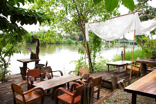 Terraza en el patio a orillas del río Mae Khlong o Meklong en un complejo hotelero retro vintage para el servicio de uso de los huéspedes por la noche en Ratchaburi Tailandia