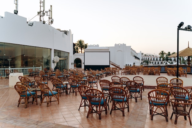Terraza de verano con mesas y sillas y escenario para actuaciones y entretenimiento en el hotel