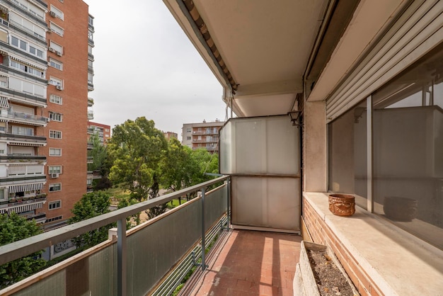 Terraza de una vivienda urbana rodeada de otros edificios similares y parques con árboles y jardines