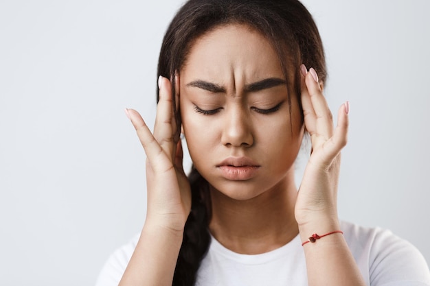 Terrible dolor de cabeza Chica tocándose las sienes sintiendo estrés