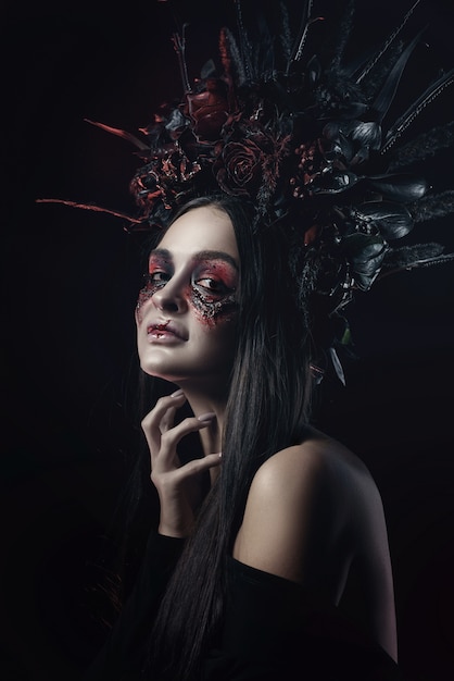Terrible horror Retrato de mujer vampiro de Halloween. Belleza vampiro bruja dama con sangre en la boca posando en el bosque profundo. Diseño de arte de moda. sostiene una vela en sus manos y lee maldiciones