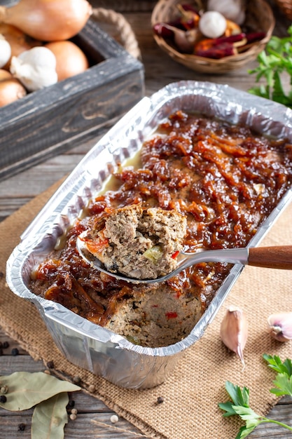 Terrina de pollo fresco con verduras y hierbas en una tabla para cortar madera