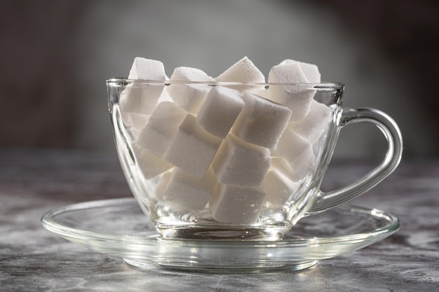 Terrones de azúcar blanca en vaso de vidrio transparente