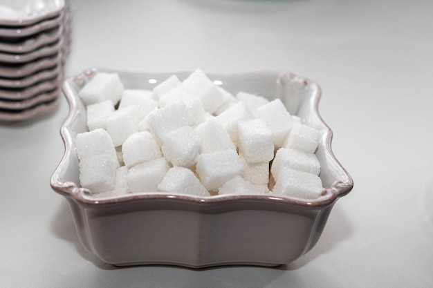 Terrones de azúcar en un recipiente cuadrado blanco