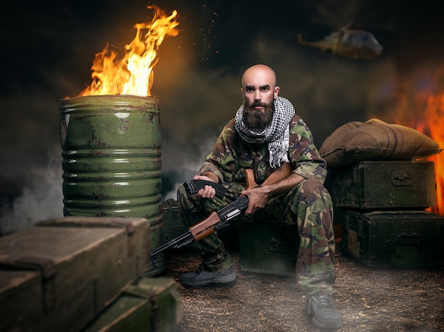 Foto terrorista barbudo em uniforme carrega arma