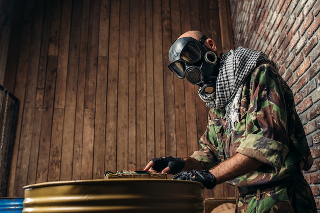 Foto terrorista de uniforme atira bomba nos barris