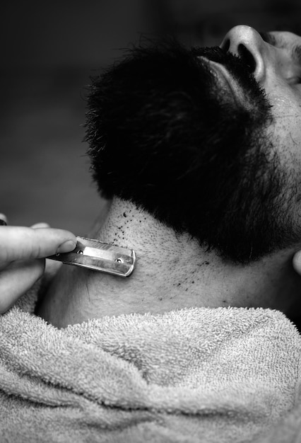 Tesoura de barbeiro e barbear reto Tão elegante e elegante Retrato de homem elegante barba estilo de cabelo e estilista de cabelo corte de estilo de barba Ferramentas de barbearia em fundo de madeira antiga com copyspace