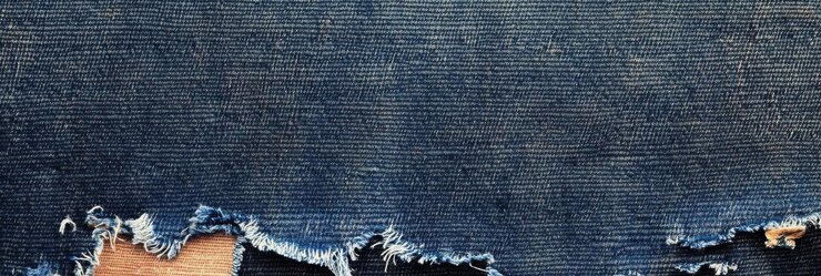 Foto tesouro de denim azul desgastado em close-up de material texturizado desgastado com bordas desvendadas